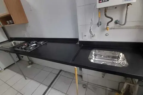 Bancada de cozinha em granito preto com cuba e cooktop - trabalho da Marmoraria Ita em Praia Grande